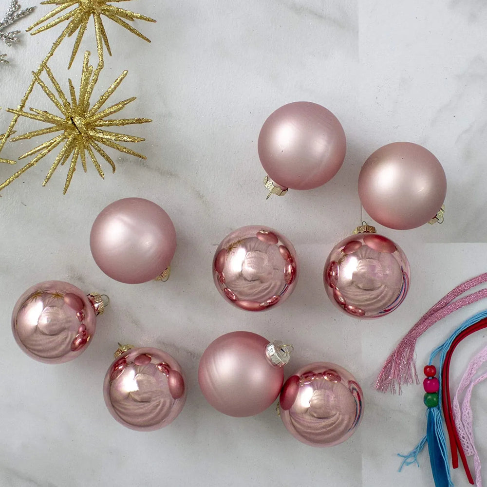 Nine pink glass Christmas baubles with gold caps