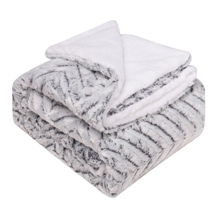 Thick sherpa blanket folded on a sofa