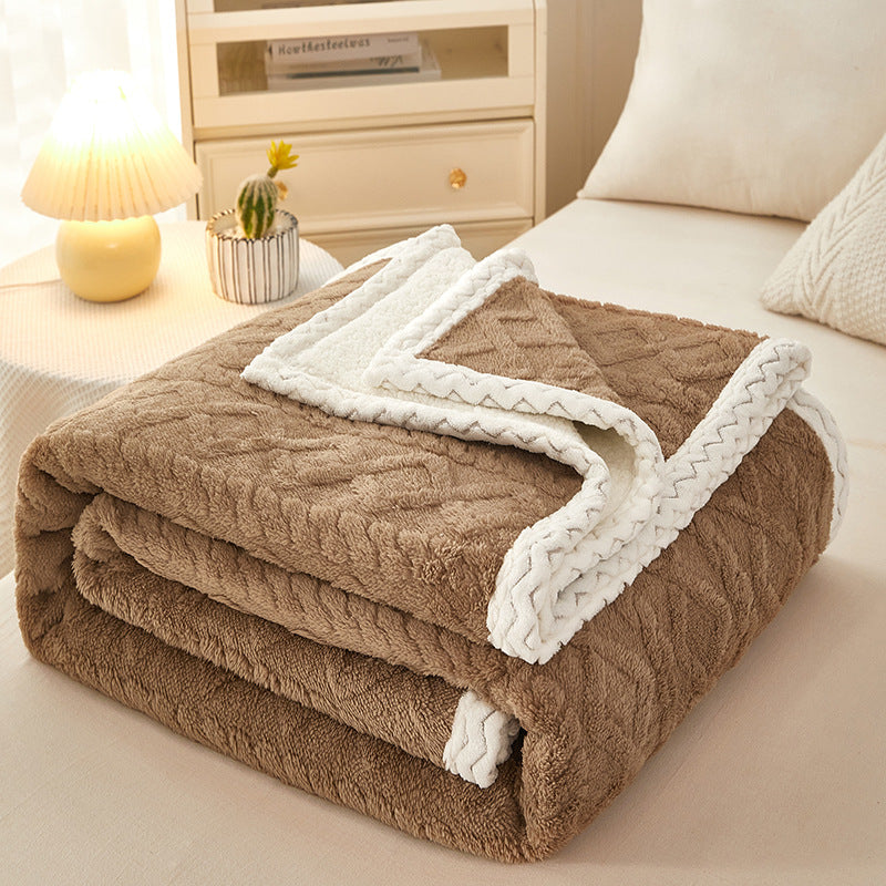 Thick sherpa fleece blanket folded on bed