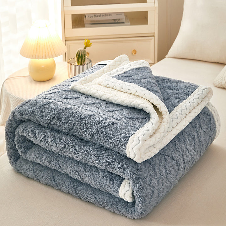 Thick sherpa fleece blanket folded on bed