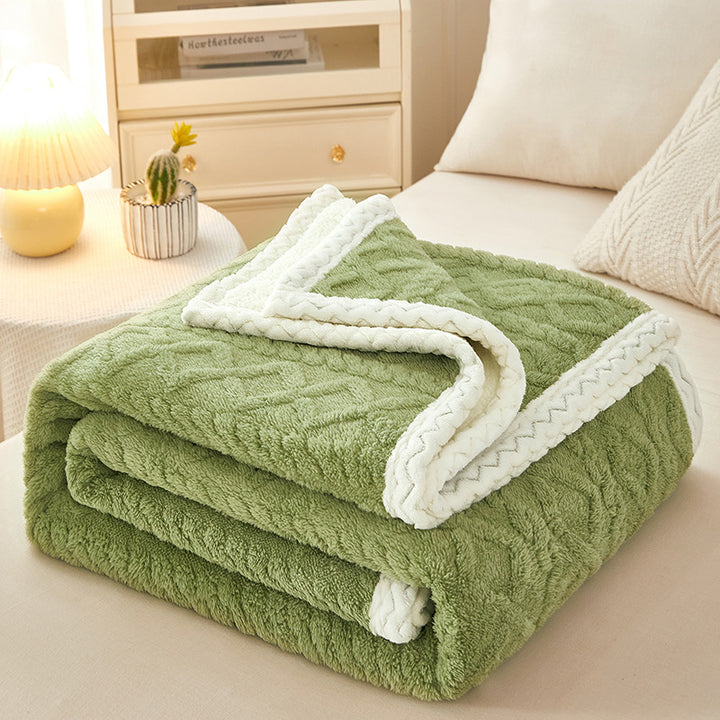 Thick sherpa fleece blanket folded on bed