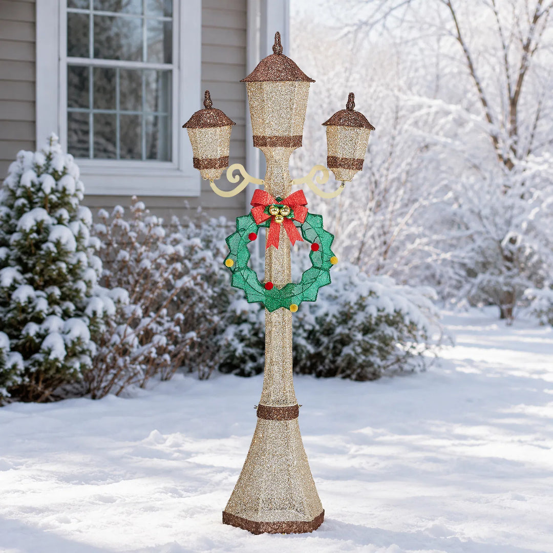 Gold lit Christmas lamp post with wreath