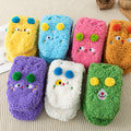 Fluffy yellow socks with embroidered face and pompoms