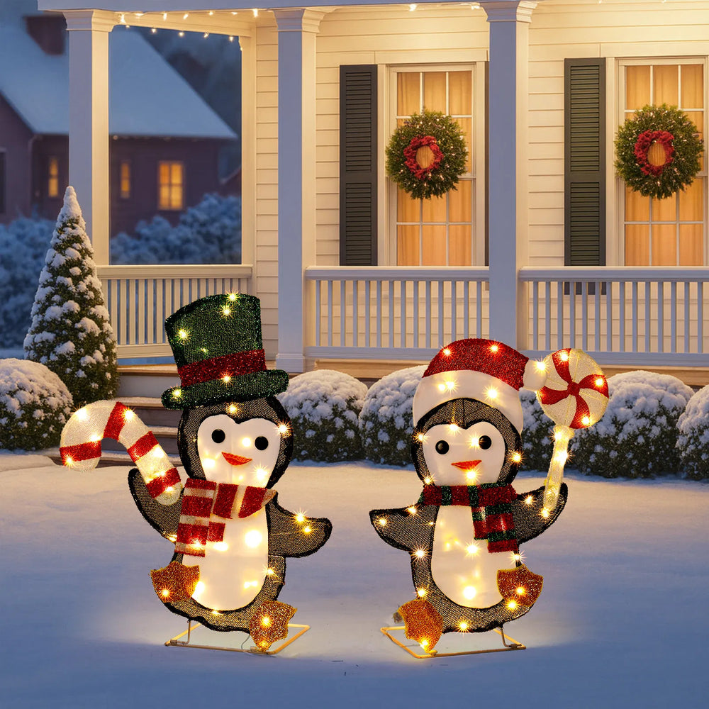 Two light-up Christmas penguins with candy canes