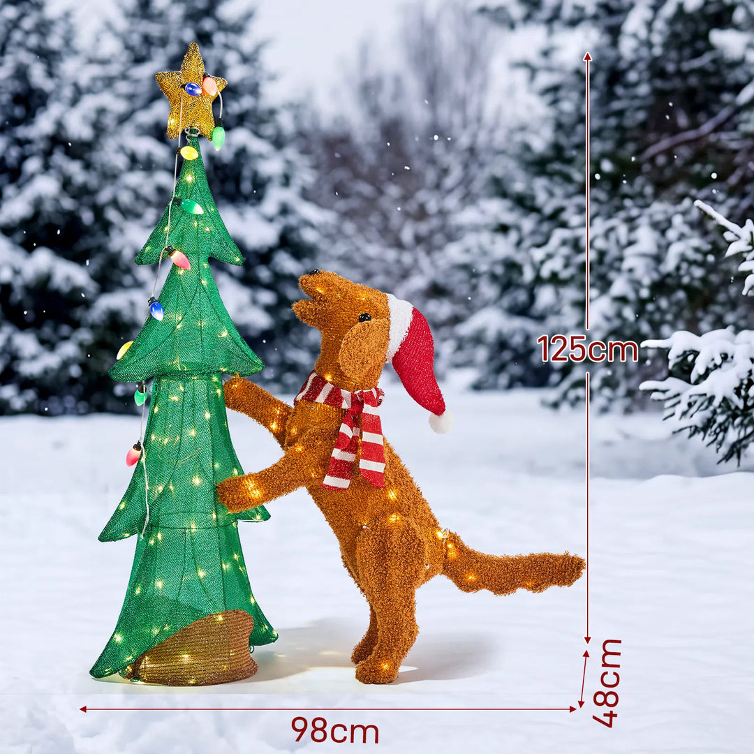 Plush dog climbing a lit Christmas tree
