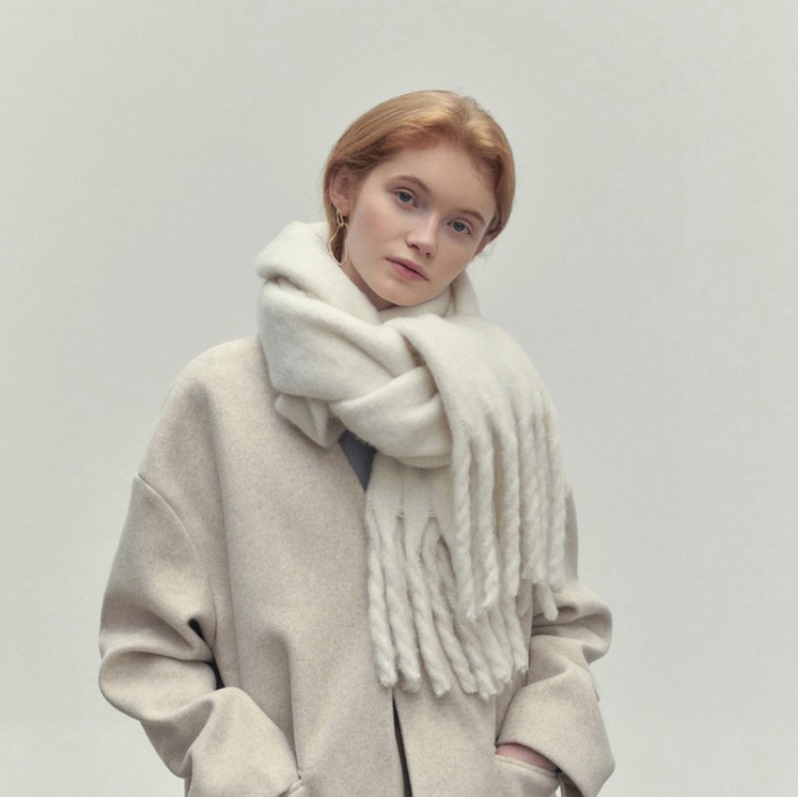 Woman wearing long ivory scarf with tassels