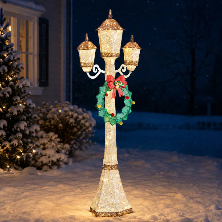 Gold lit Christmas lamp post with wreath